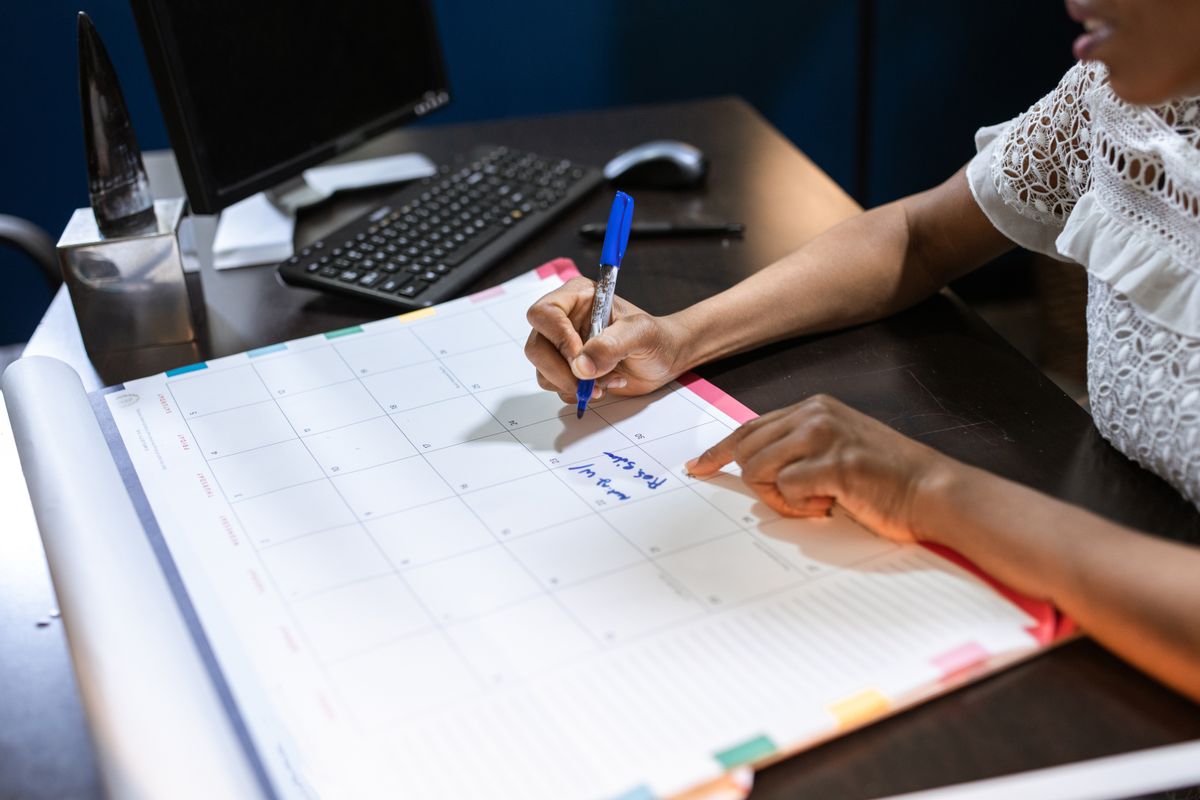 Reviewing and marking dates on a desk calendar