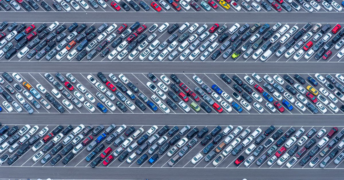 Aerial view of a completely full parking lot with rows of parked cars