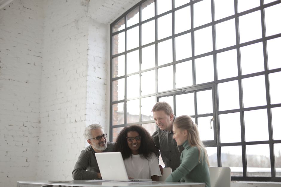 Team reviewing data on a laptop in a bright office