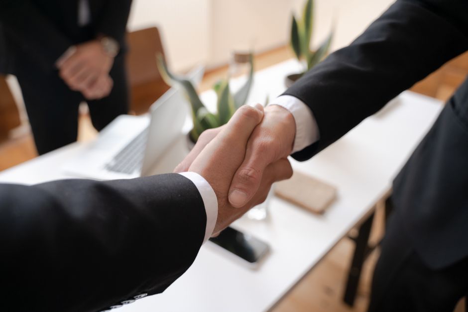 Two people shaking hands after negotiating a deal