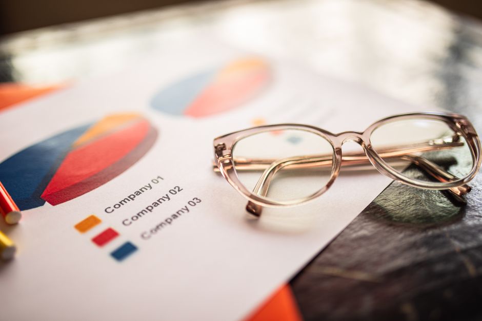 Pie chart reports comparing figures across three companies on a desk